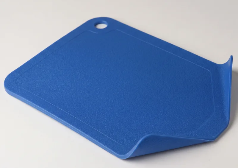 Plastic cutting board with curved edges